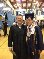 A smiling graduated student posing with a faculty member